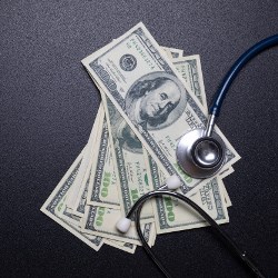 one hundred dollar bills with stethoscope